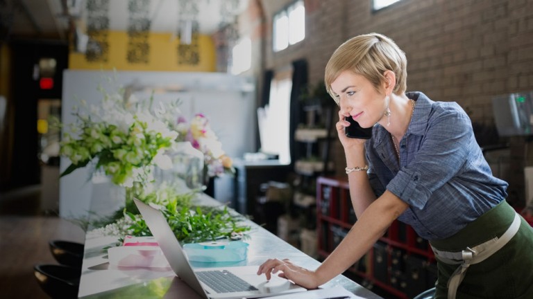 Florist working with laptop in a flower shop